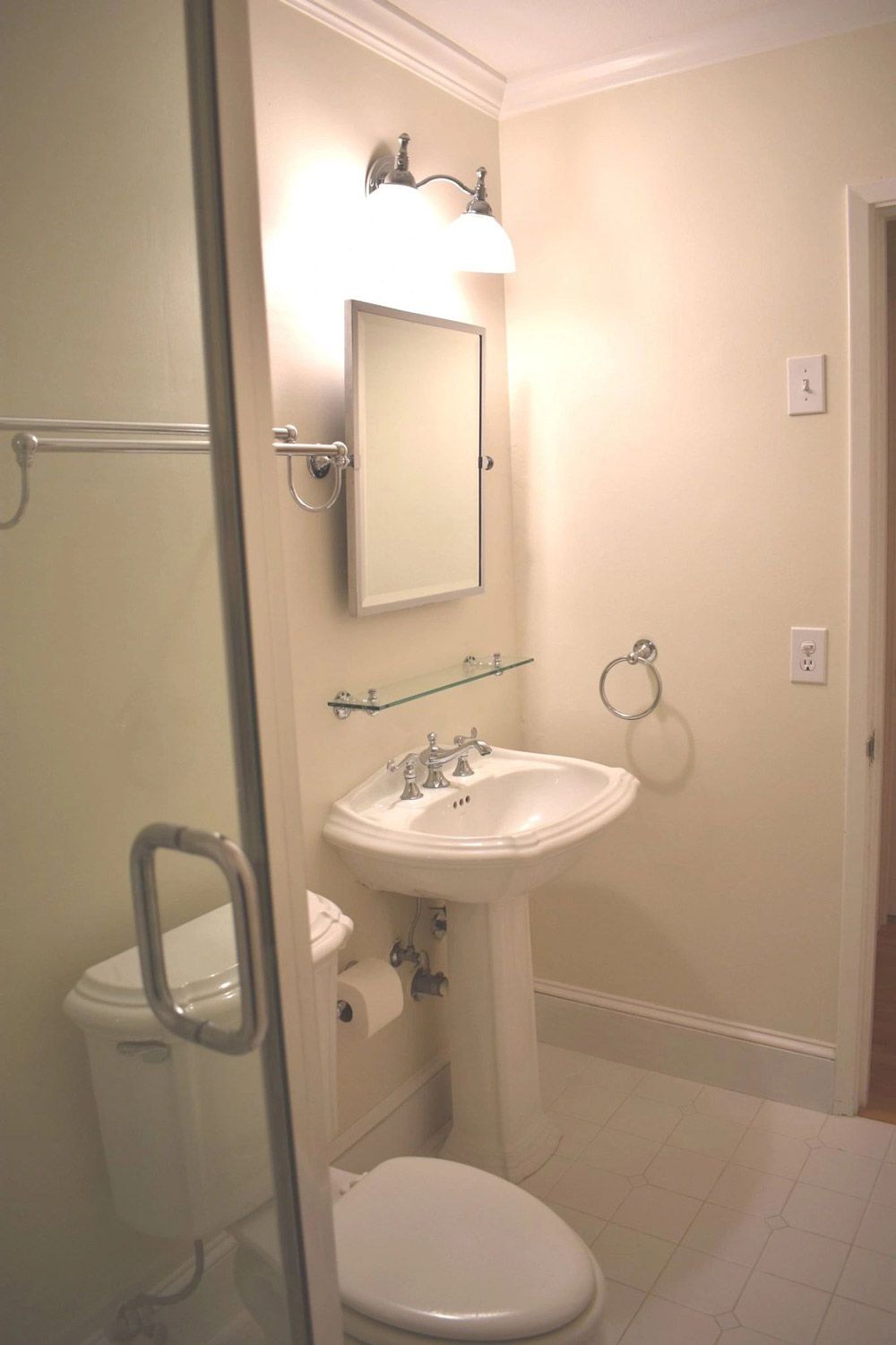 A bathroom with a toilet a sink and a mirror
