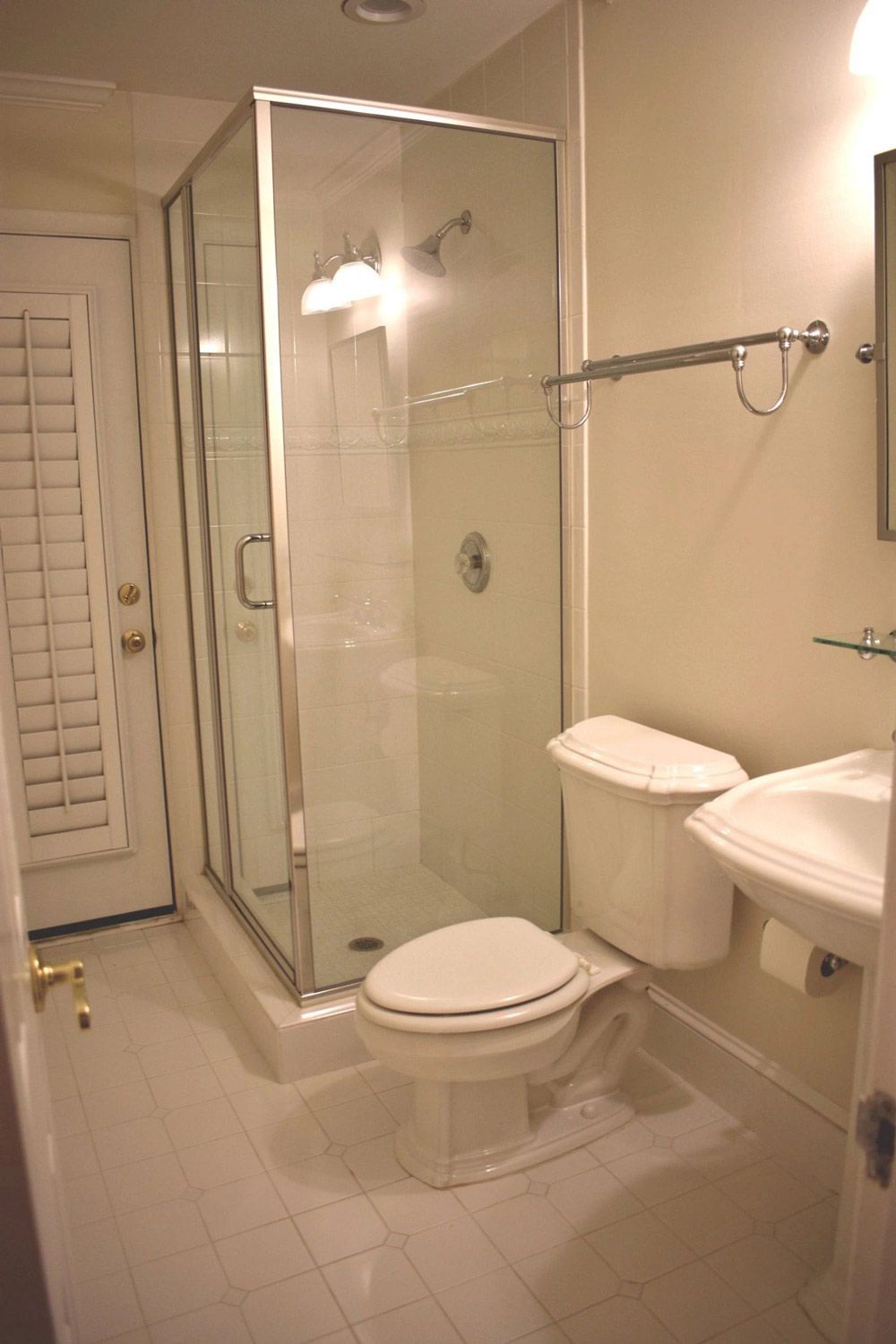 A bathroom with a toilet , sink and shower.