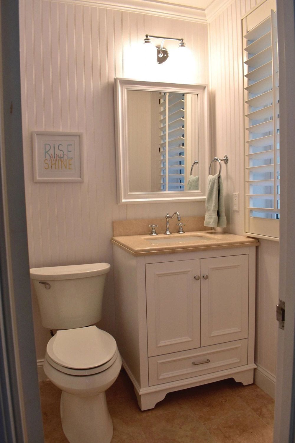 A bathroom with a toilet a sink and a mirror