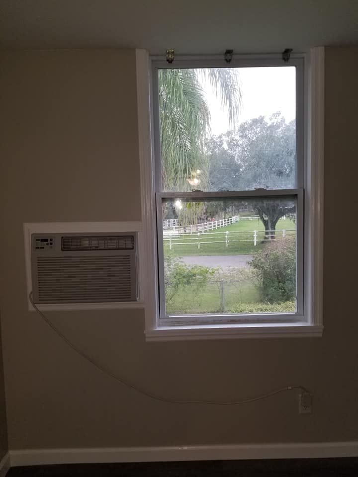 A room with a window and a window air conditioner.
