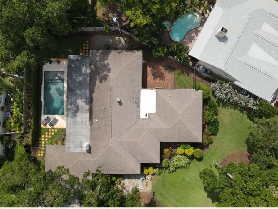 An aerial view of a house with a pool in the backyard