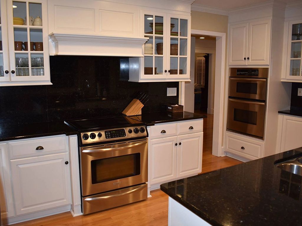 A kitchen with stainless steel appliances and white cabinets
