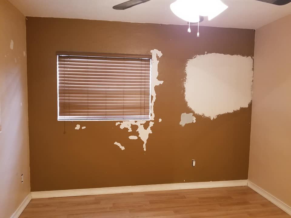 An empty room with a window and a ceiling fan