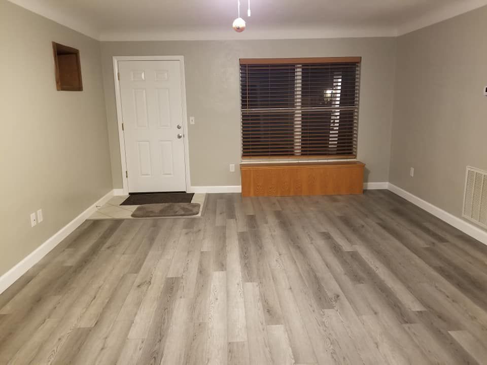 A living room with hardwood floors and a window.