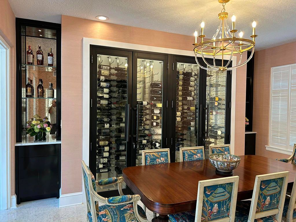 A dining room with a table and chairs and a wine cellar.