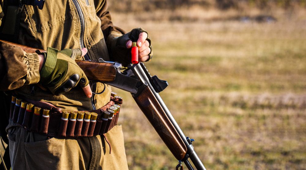 A Person Wearing a Brown Jacket Reloading a Shotgun — Mackay Shooters Supplies in Paget, QLD