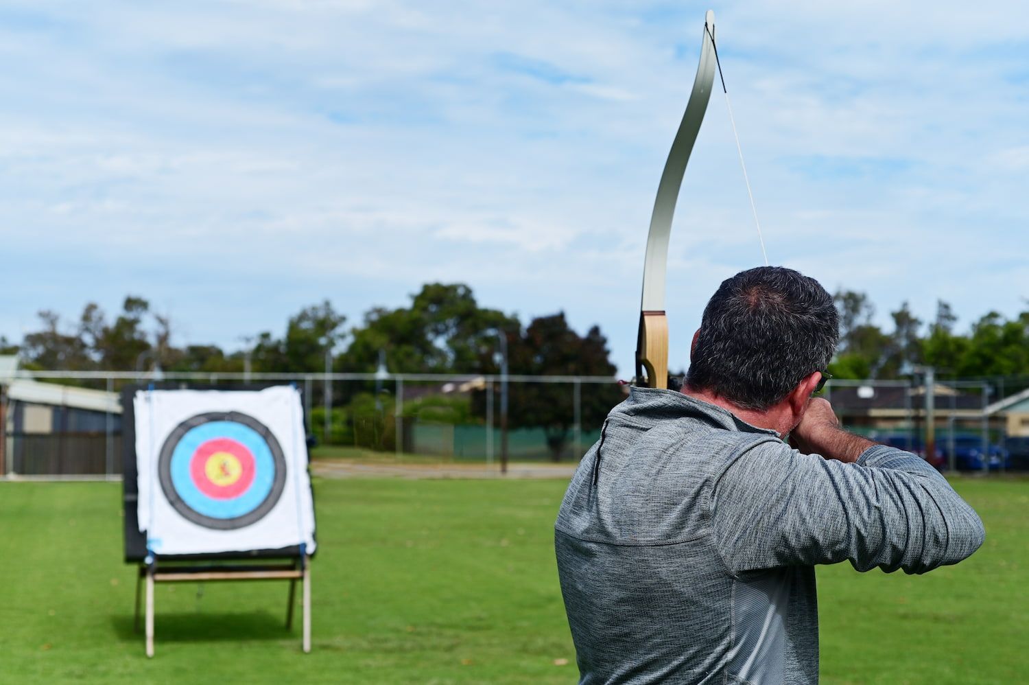 A Man is Aiming a Bow at a Target in a Field — Mackay Shooters Supplies in Paget, QLD