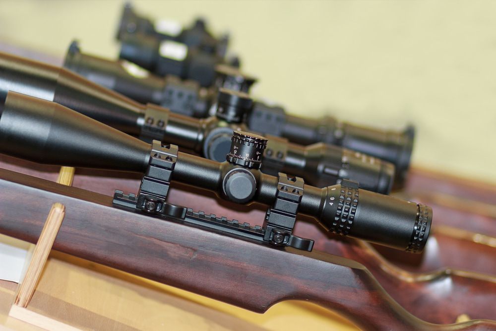 Close-up of Multiple Black Rifle Scopes on Wooden Gun Stocks, Lined in a Rack — Mackay Shooters Supplies in Paget, QLD