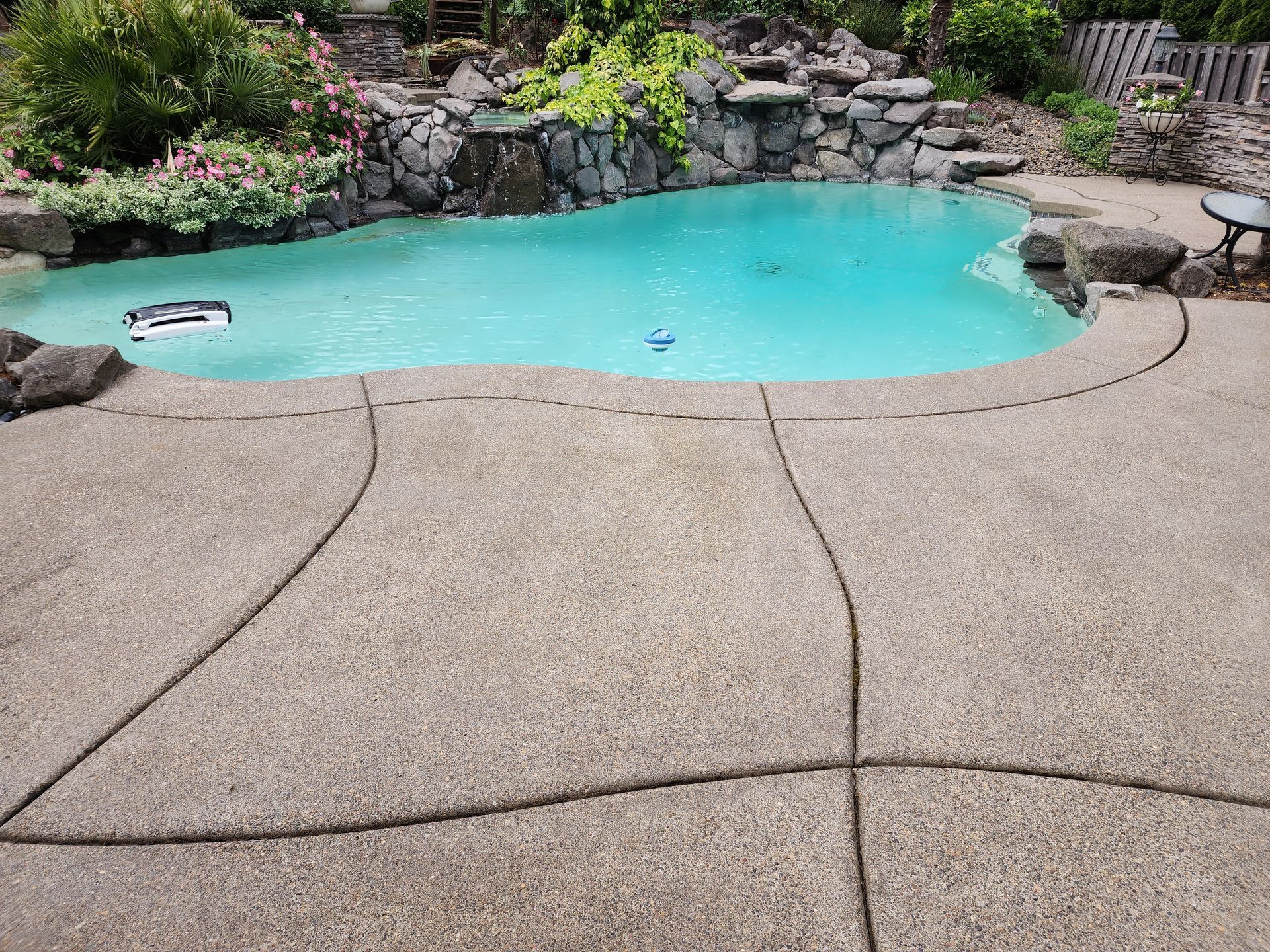 Hot water pressure washing removing mold from a home's Concrete in Tigard Oregon