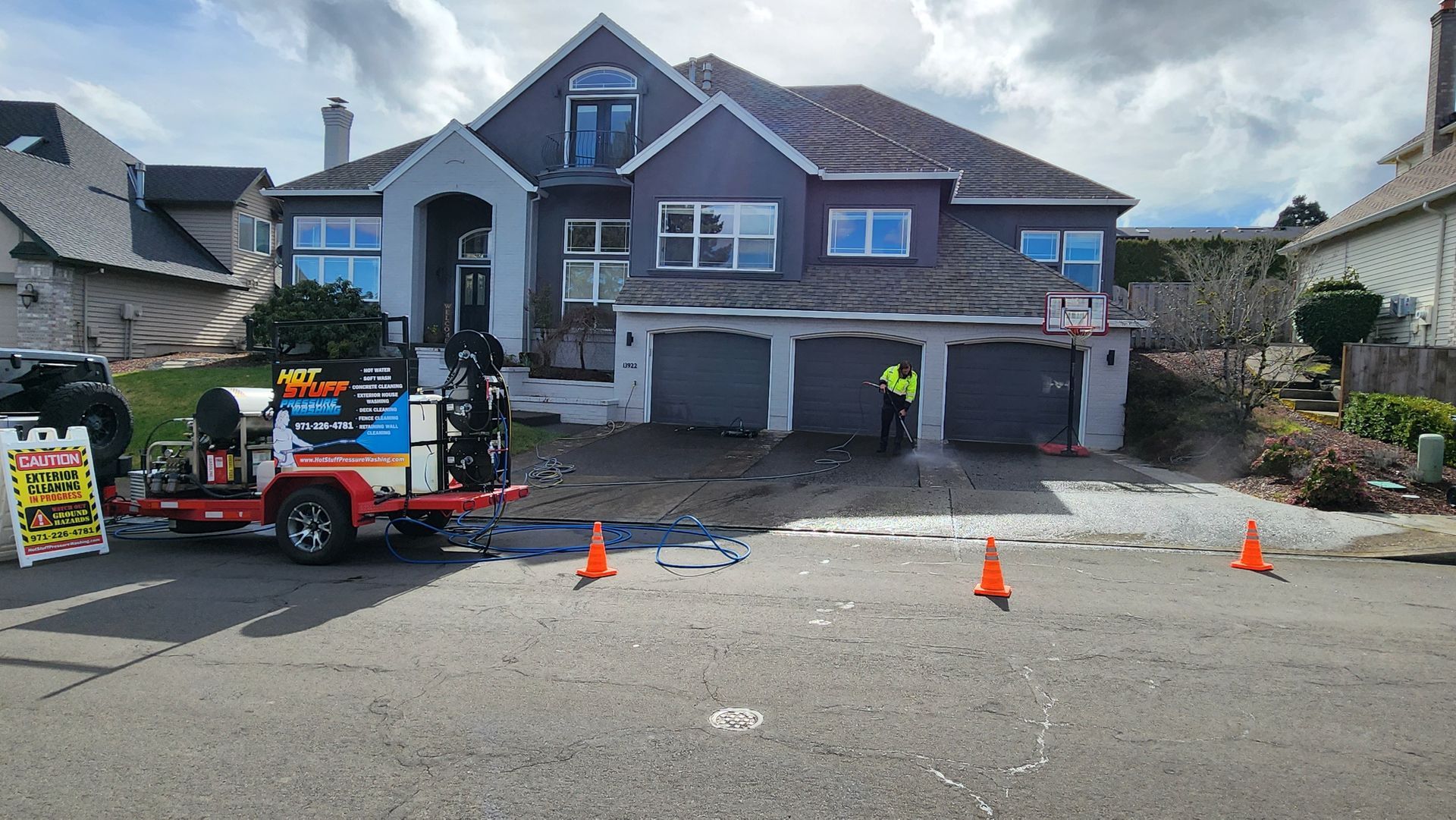 High-pressure hot water cleaning a concrete driveway, removing dirt and grime in Tigard Oregon