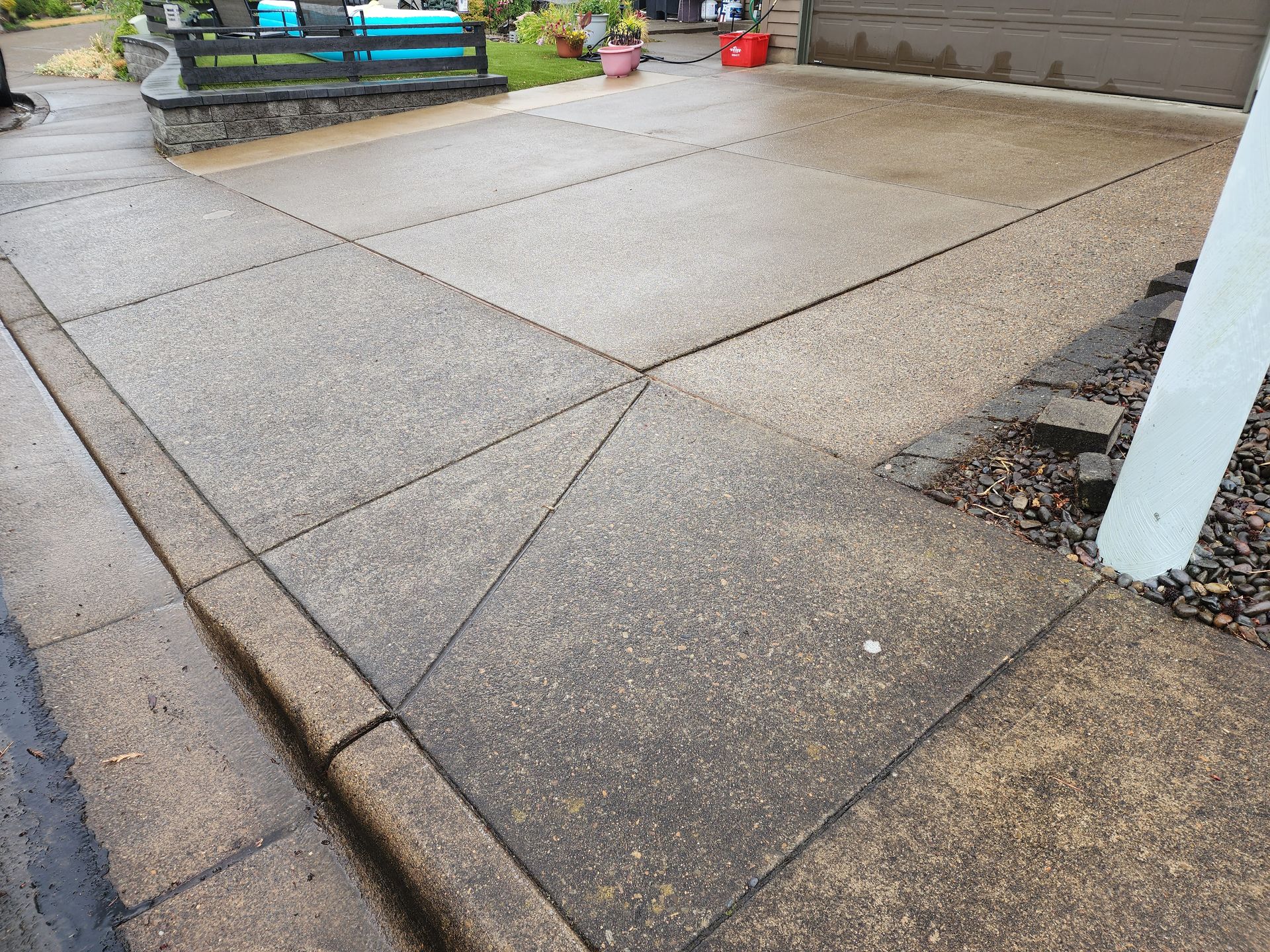 Hot water pressure washing removing mold from a home's Concrete in Tigard Oregon