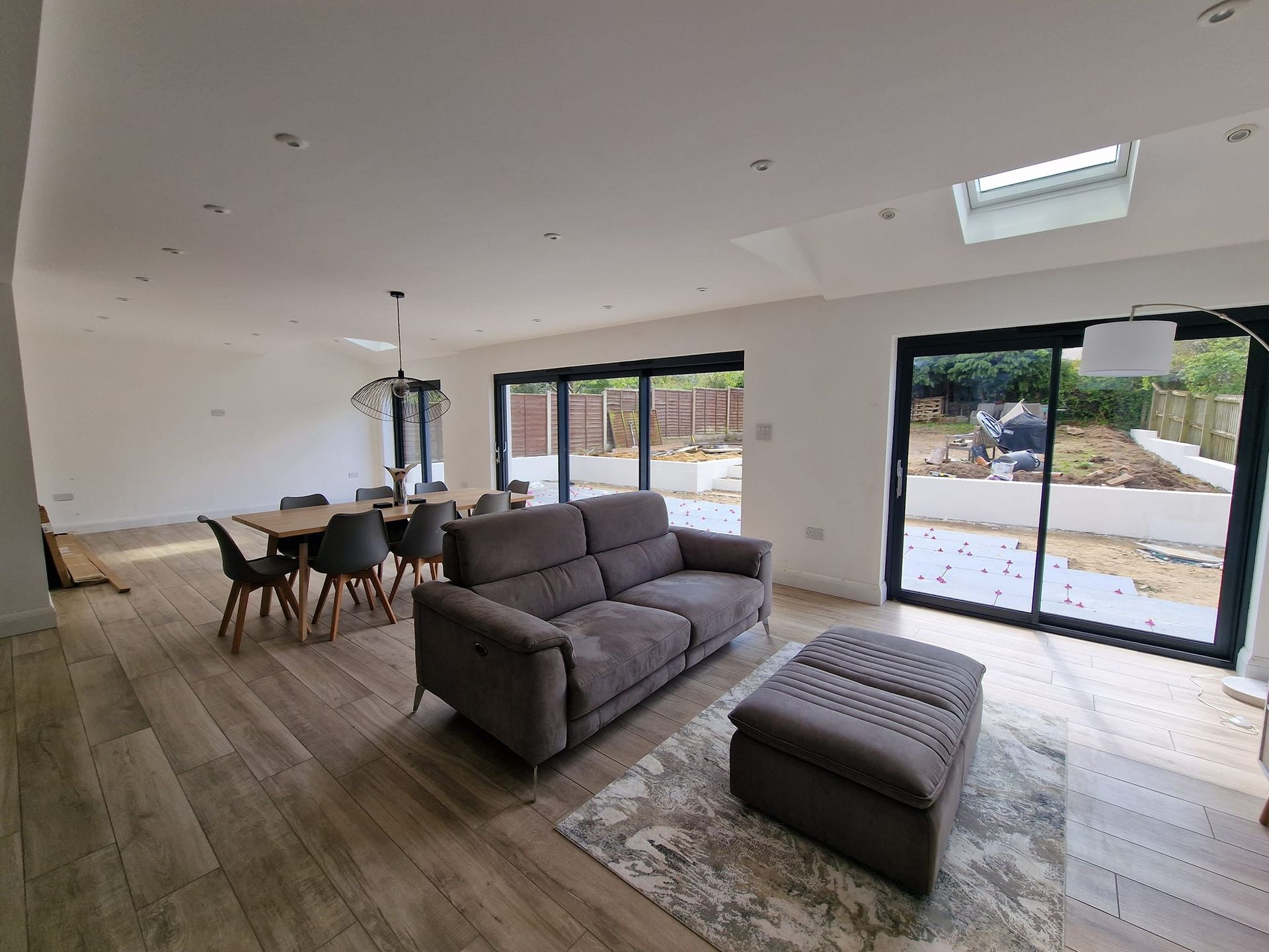 A newly altered beautiful living room in Suffolk, with a couch , ottoman , table and chairs.