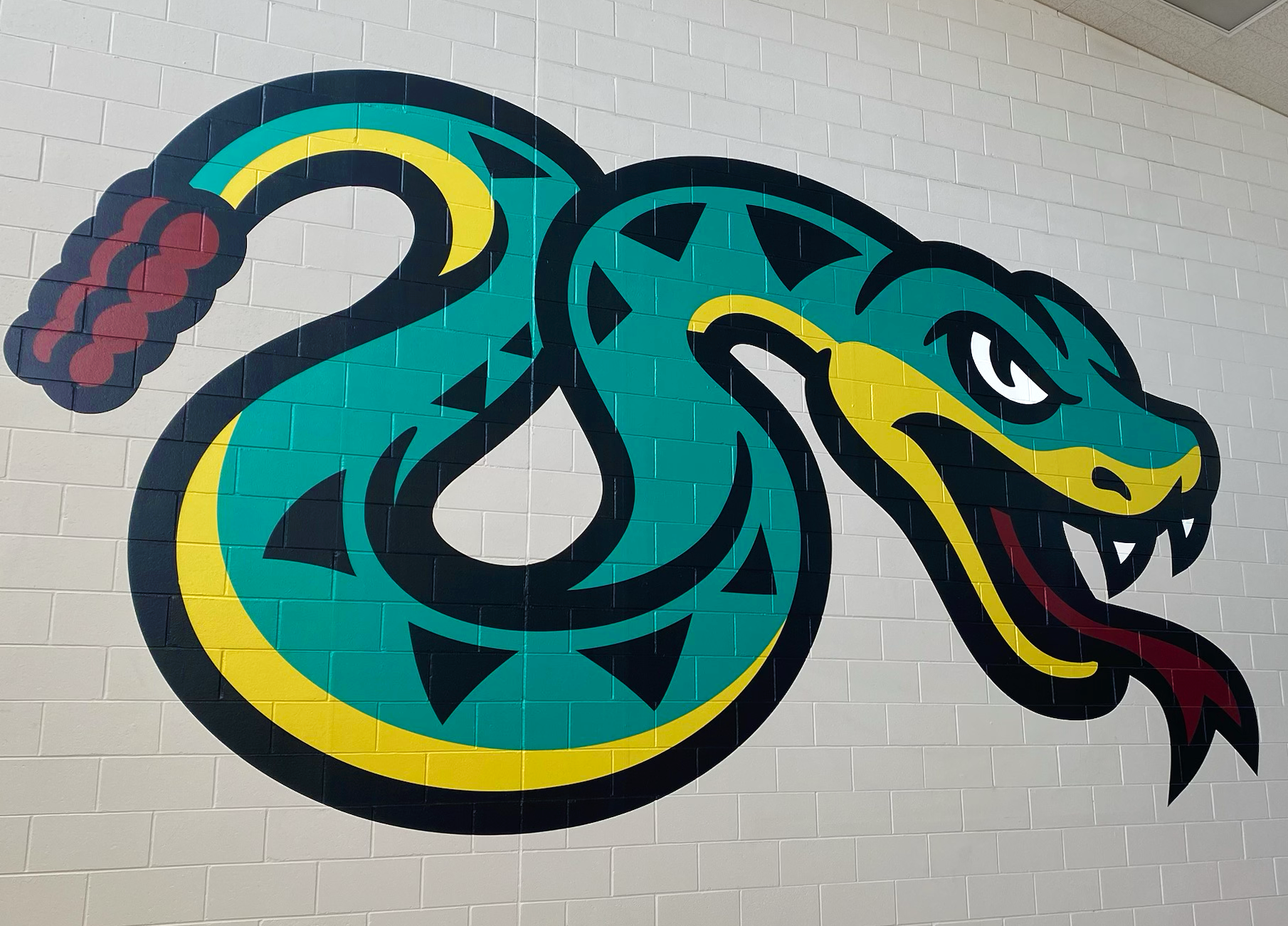 A drawing of a snake on a white brick wall