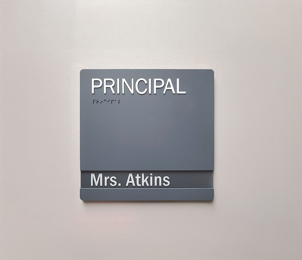 A sign on a wall that says principal mrs. atkins