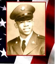 Sepia portrait of a man in military dress uniform, framed against a red, white, and blue flag background