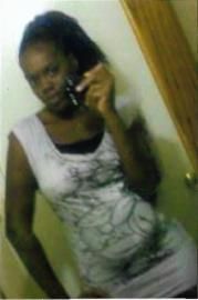 Person taking a mirror selfie in a white top, standing indoors near a door.