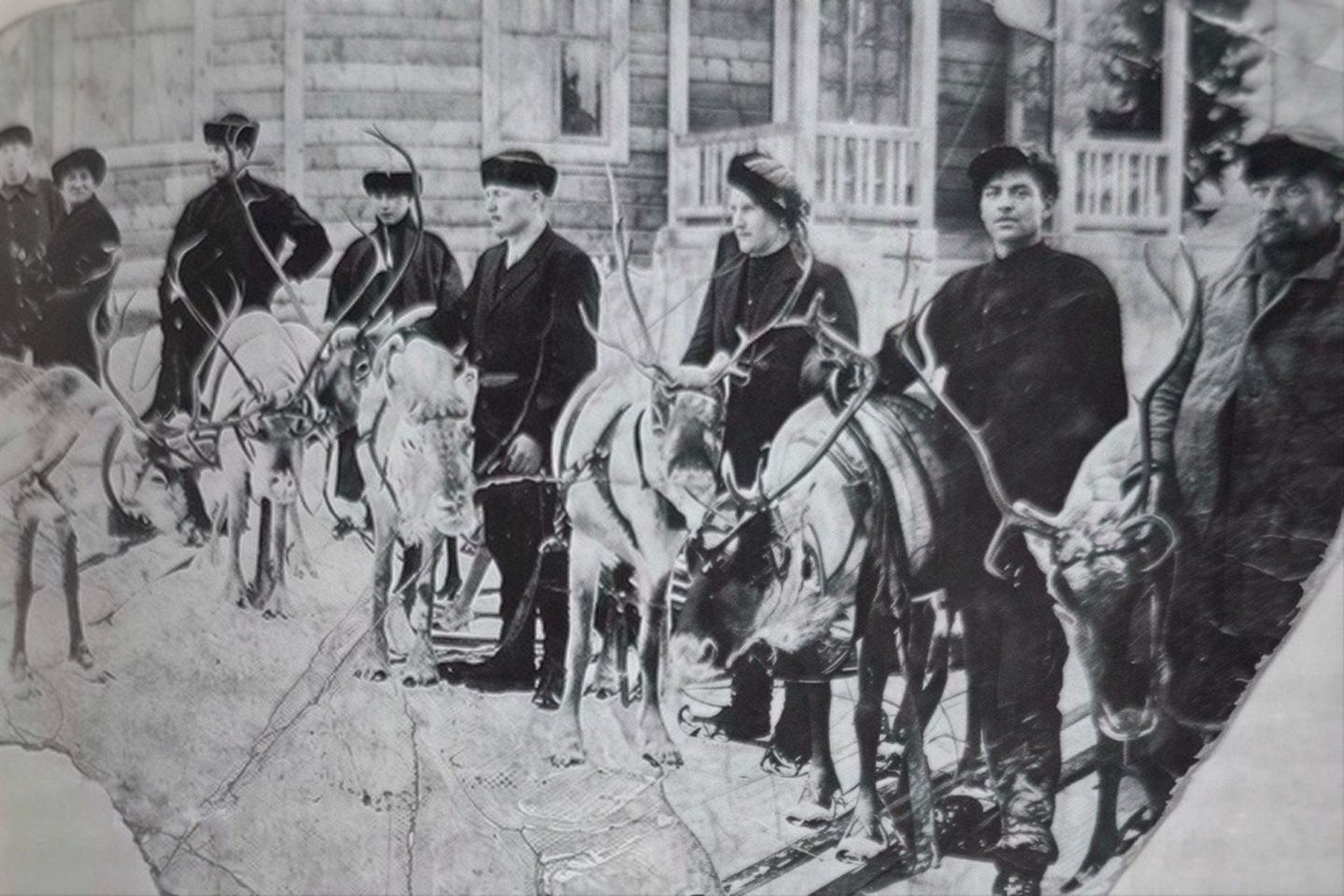 Historic family photograph with reindeer outside a wooden home in Finnish Lapland