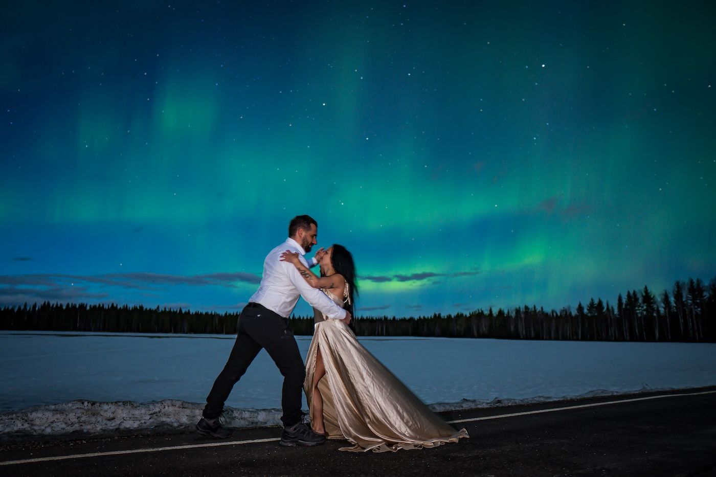 Bride and groom dancing under the Aurora during Arctic GM honeymoon tour in Levi