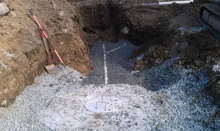 A manhole cover is being installed in a hole in the ground.