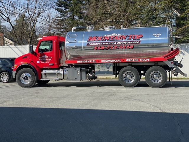 A red tanker truck is parked in a parking lot