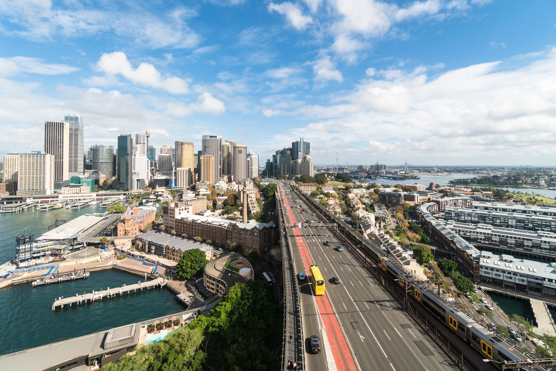 An aerial view of a city with a train going over a bridge.