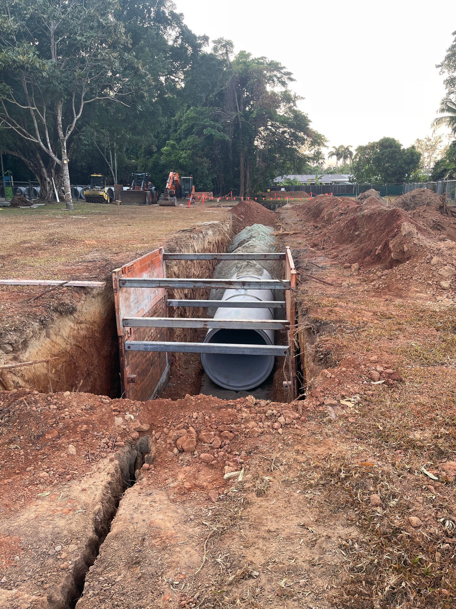 A large pipe is being installed in a hole in the ground.