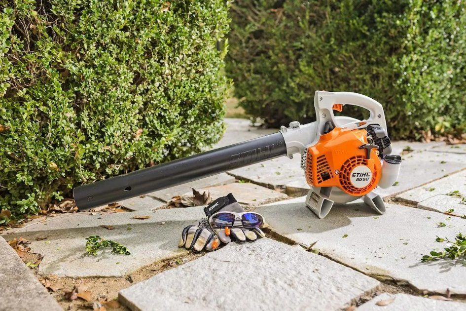 A Stihl Leaf Blower Is Sitting on A Sidewalk Next to A Pair of Gloves — Stihl Shop Grafton in Clarence Valley, NSW