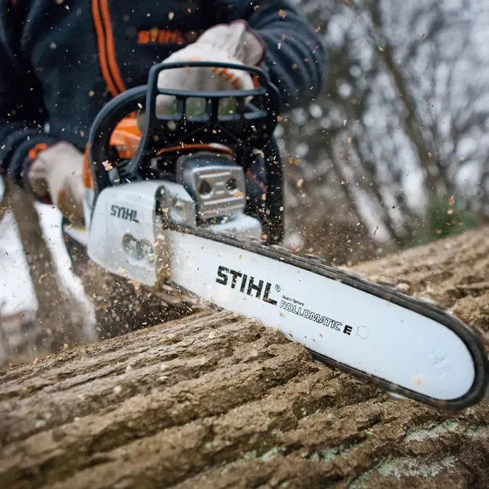 A Man Is Using a Stihl Chainsaw to Cut a Log — Stihl Shop Grafton in Grafton, NSW