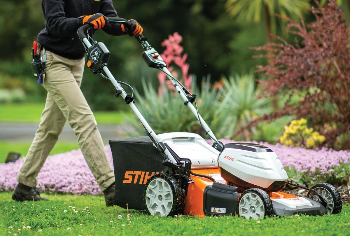 A Person Is Using a Stihl Lawn Mower on A Lush Green Lawn — Stihl Shop Grafton in Yamba, NSW