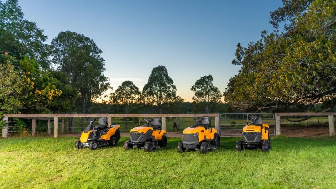 Three Yellow Lawn Mowers Are Parked in A Grassy Field — Stihl Shop Grafton in Grafton, NSW