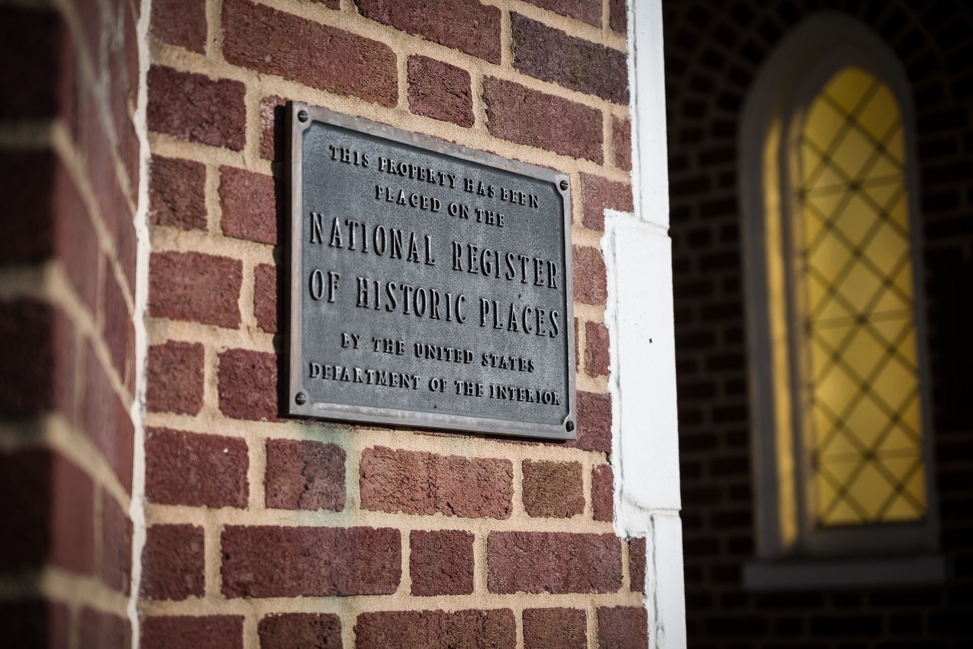 A brick wall with a sign on it that says national register of historic places