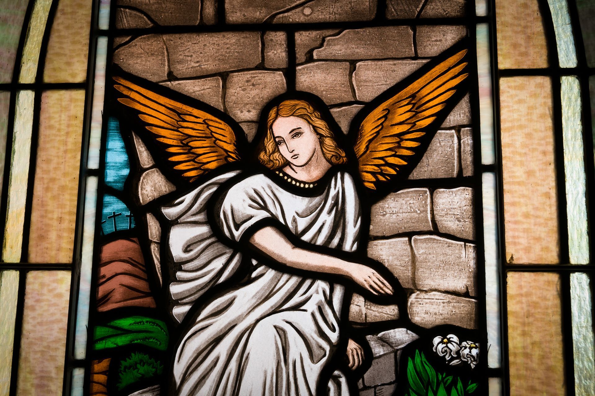 A stained glass window with a painting of an angel.