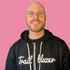 A bald man wearing a black trail blazer hoodie