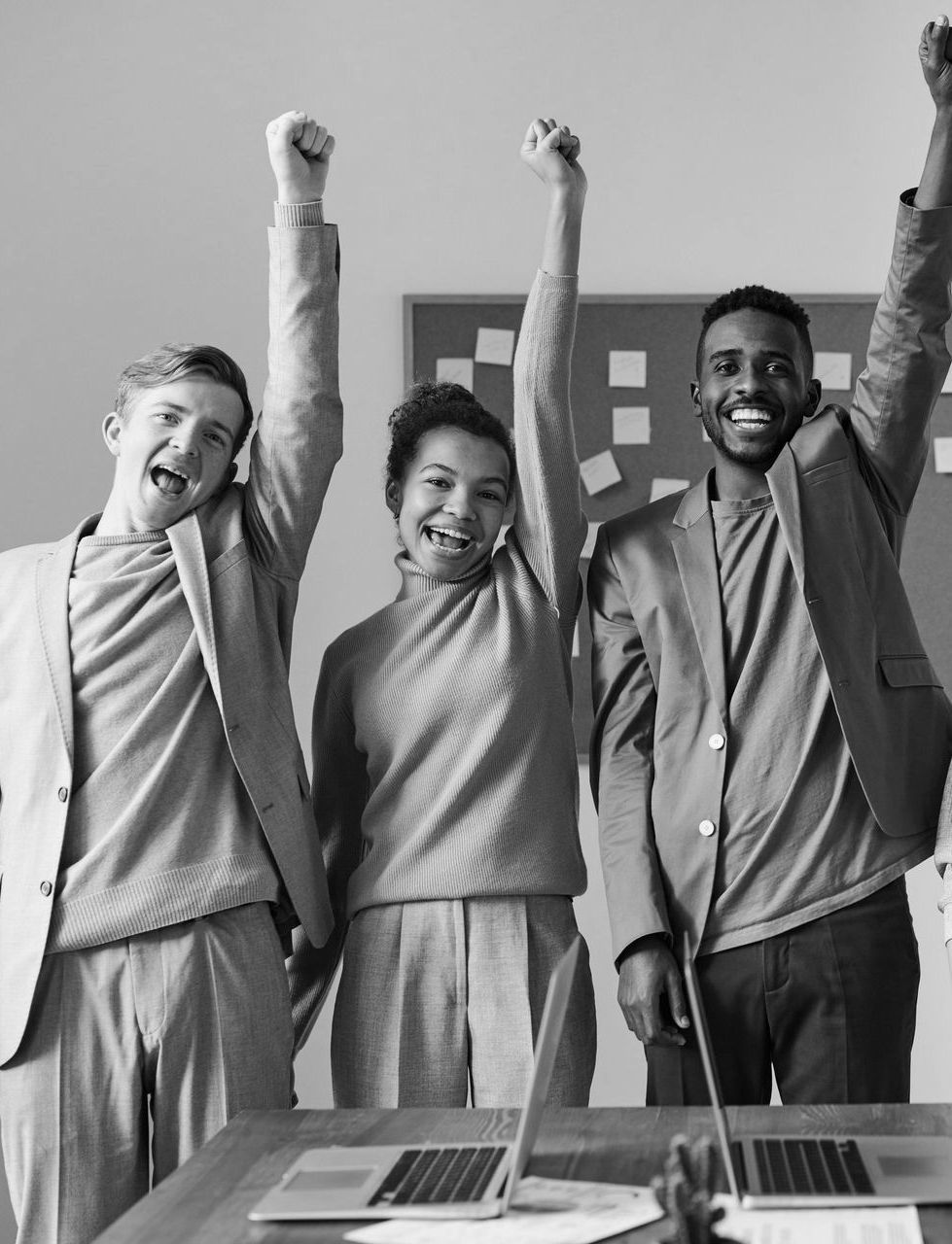 A group of people are standing next to each other with their arms in the air.