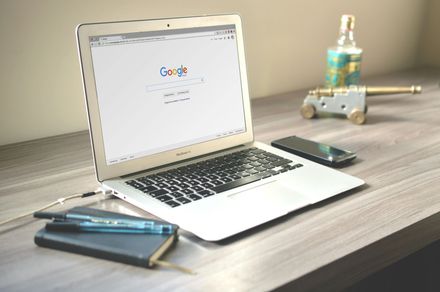 A laptop is open to a google page on a desk.