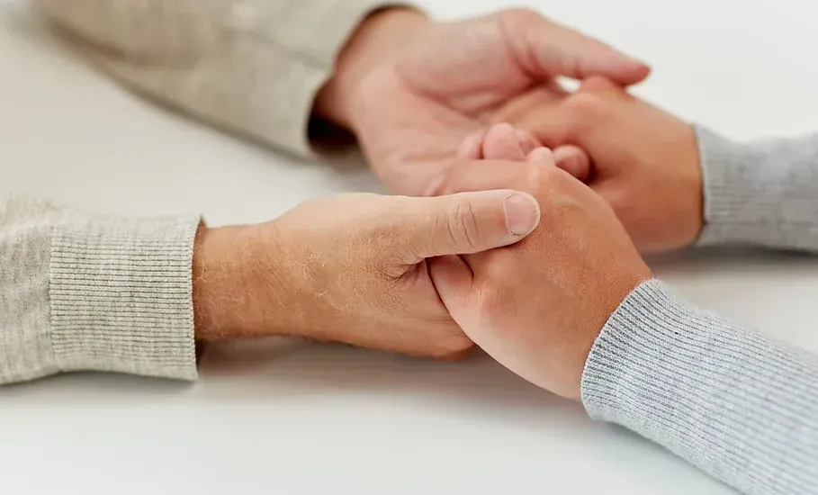 A man and a woman are holding hands on a table.