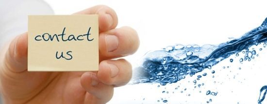 Hand holding a sticky note that says “contact us” beside a flowing blue water splash.