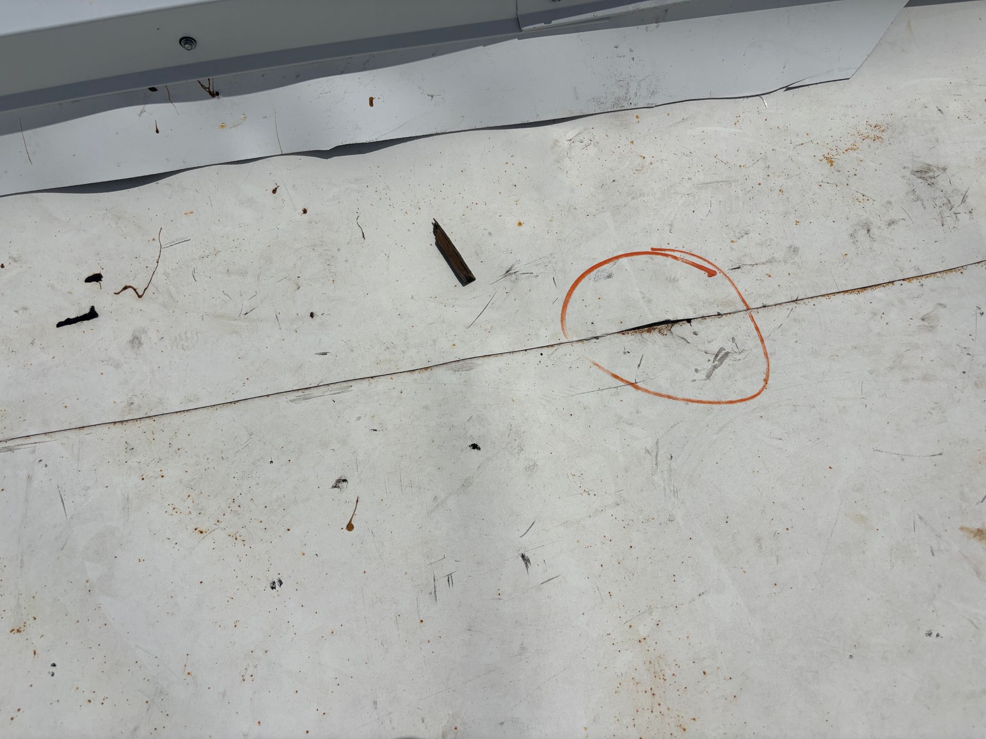 White roof surface with a dark crack, circled in red.