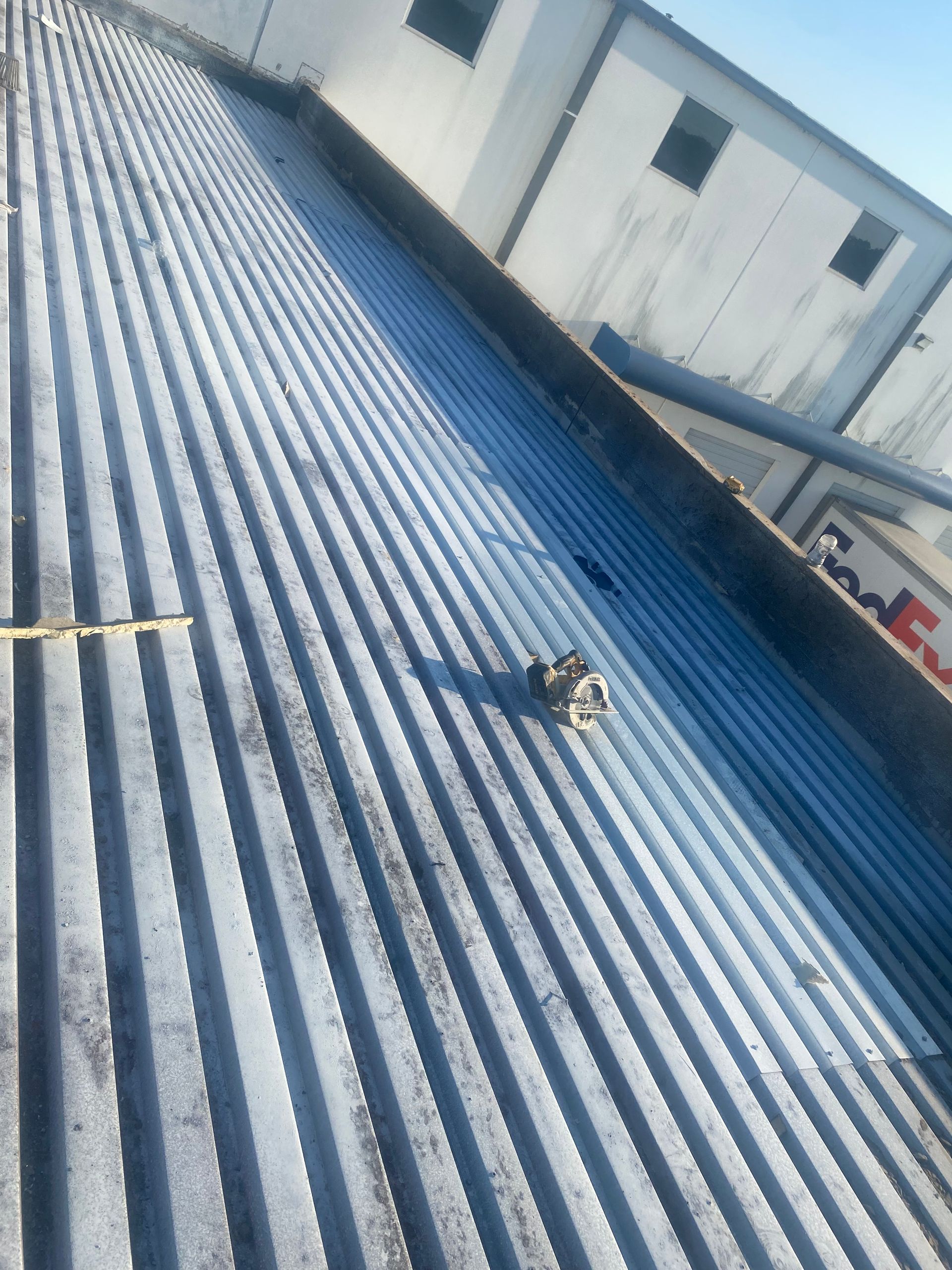 Corrugated metal roof on a building, a safety anchor is visible.