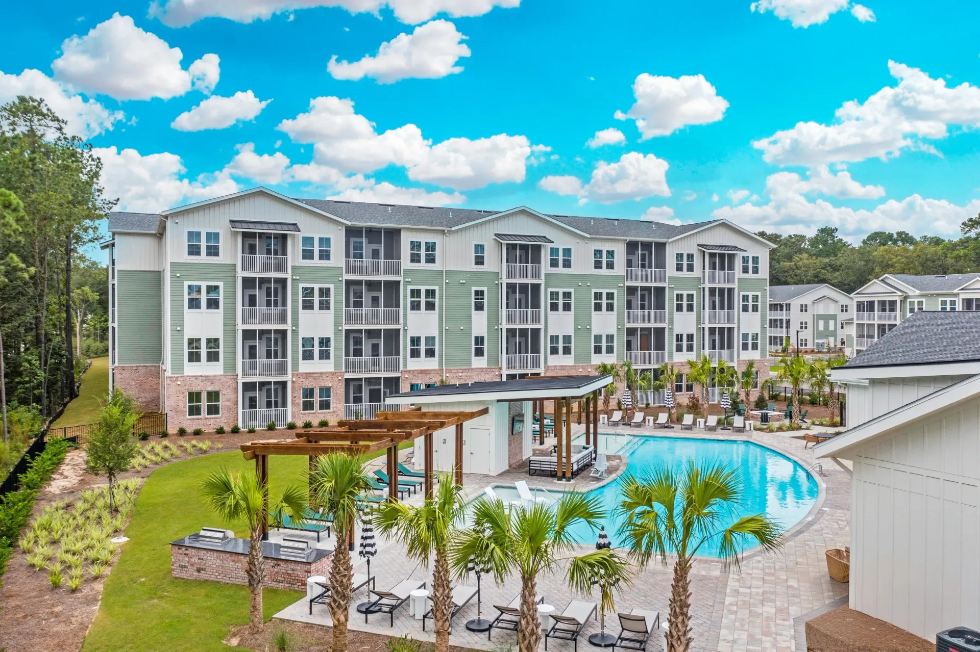 Luxury apartment complex with a resort-style pool, cabanas, and outdoor grills.