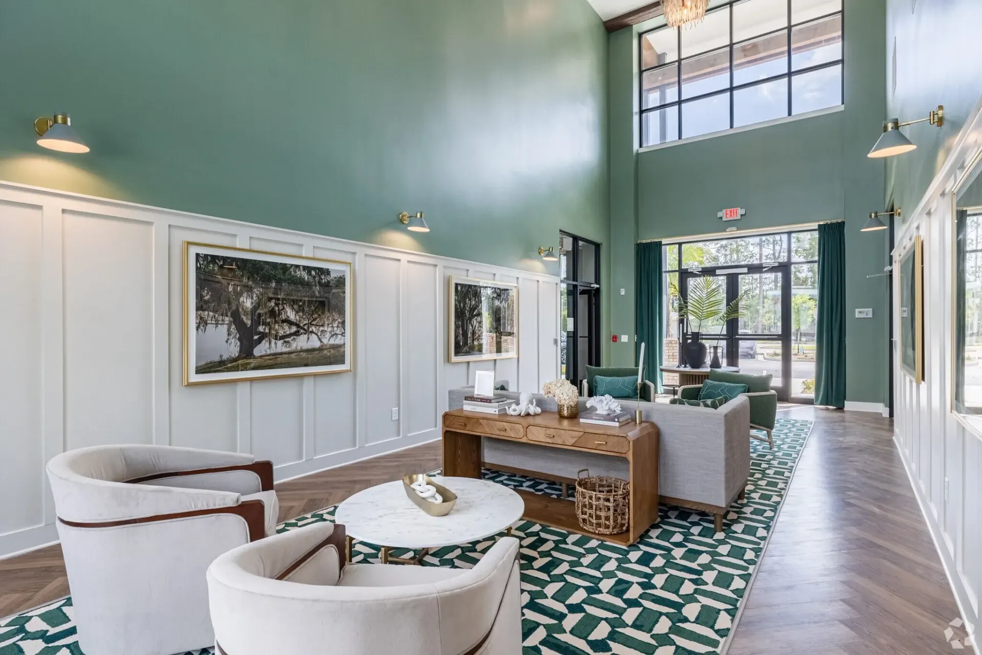 Lobby seating area with modern furniture, artwork, and large windows.