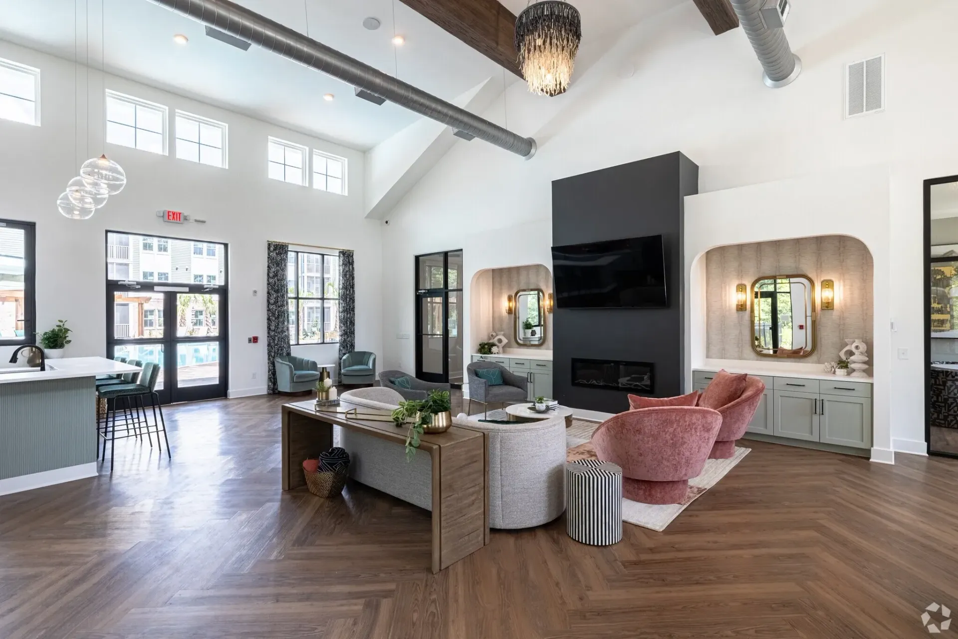 Lounge area with fireplace and TV, adjacent to pool area through glass doors.