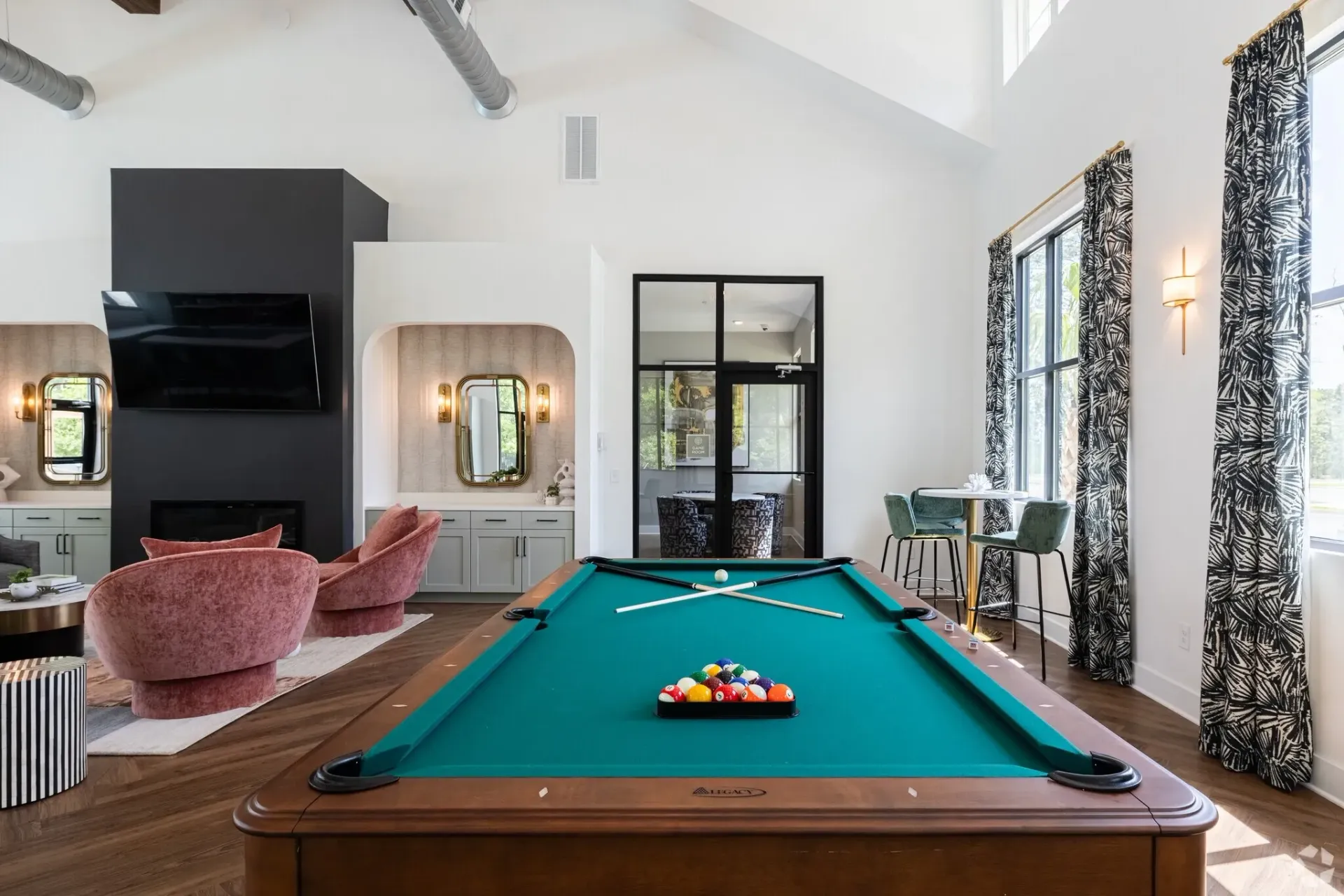 Pool table in a lounge area with stylish seating and decor.