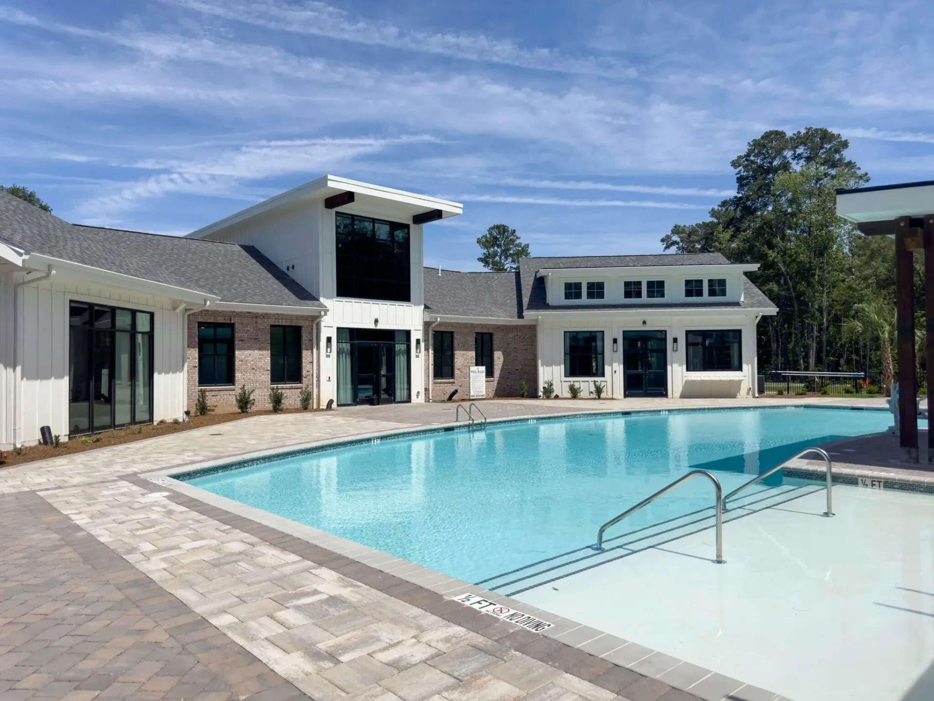 Outdoor swimming pool with lounge area and modern building exterior.