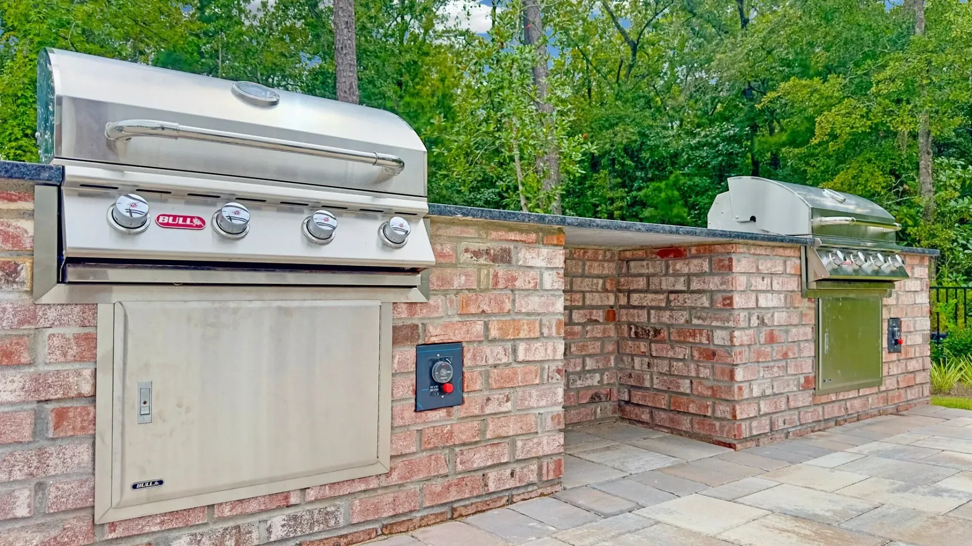 Outdoor built-in gas grills with brick counter base and granite countertop.