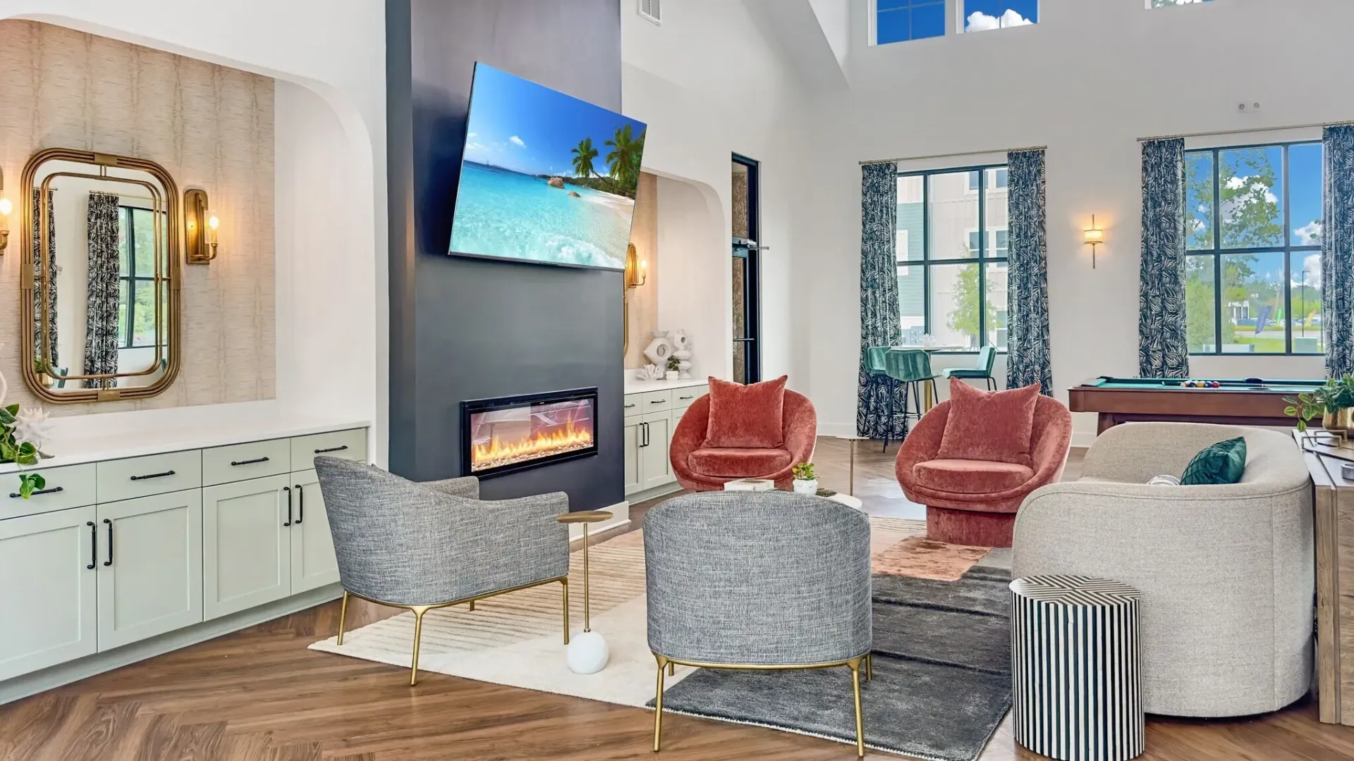 Stylish community lounge with a fireplace, TV, and pool table.