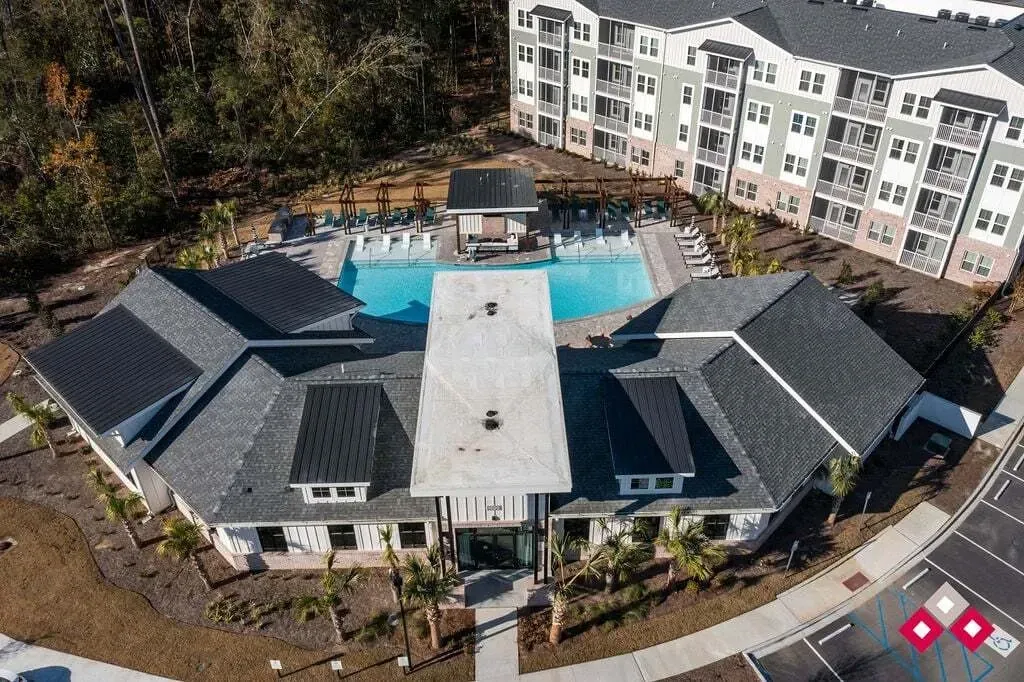 Aerial view of apartment complex with swimming pool and building exteriors.