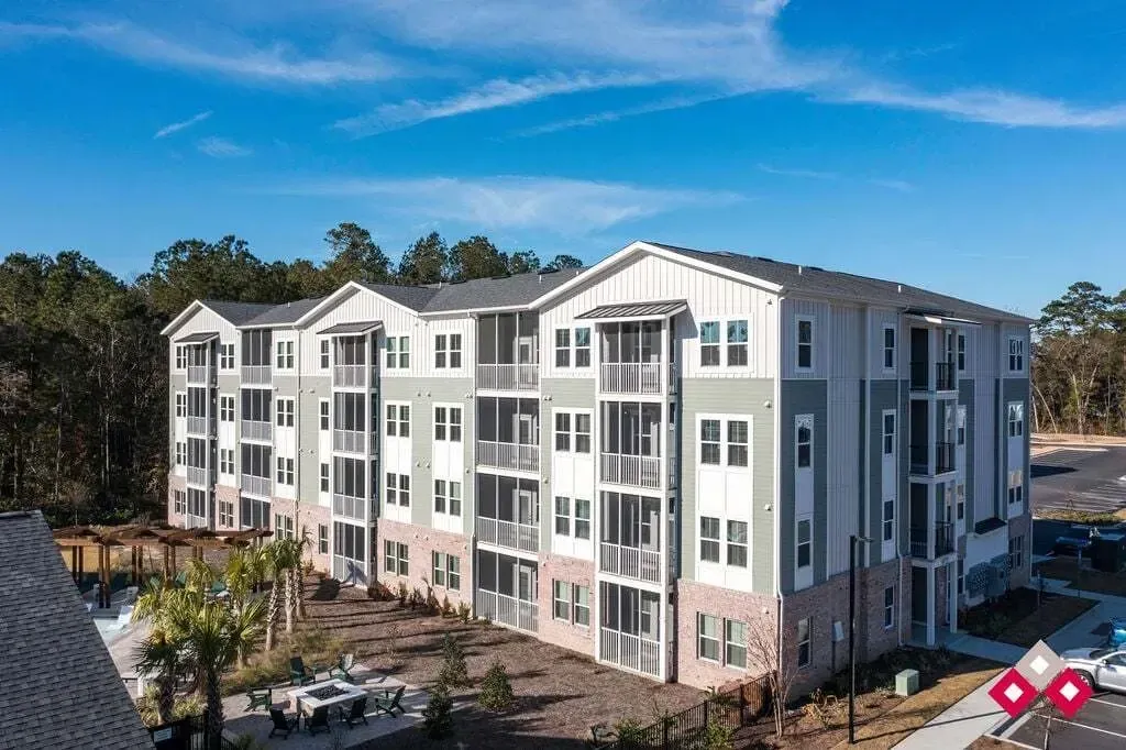 Exterior of a multifamily apartment building with balconies and a courtyard.