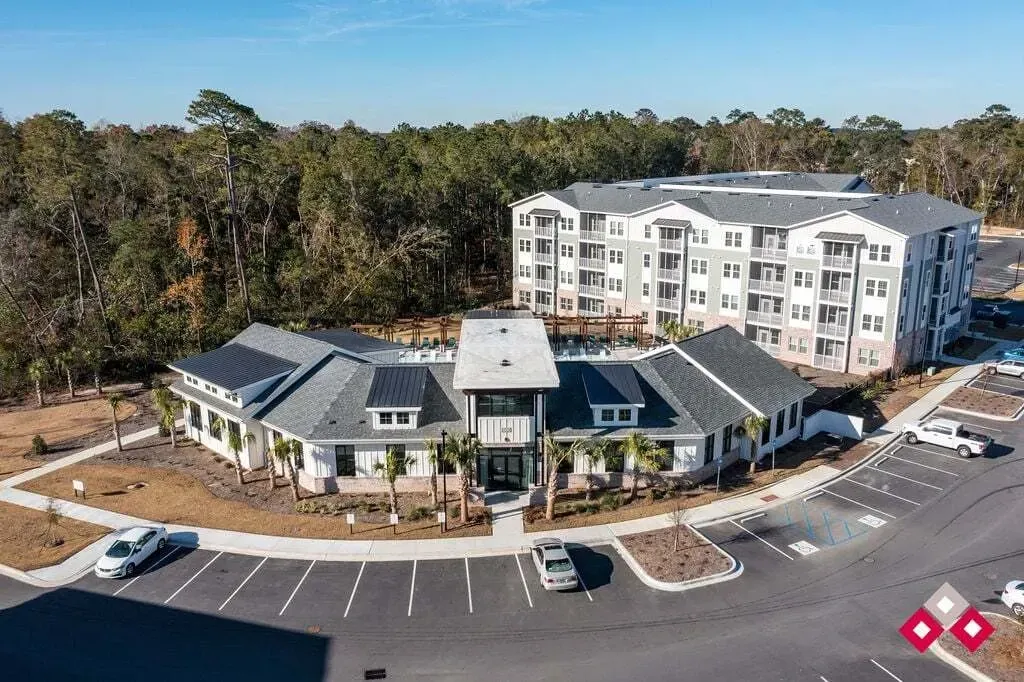 Exterior view of a modern apartment complex with multiple buildings and a central clubhouse.