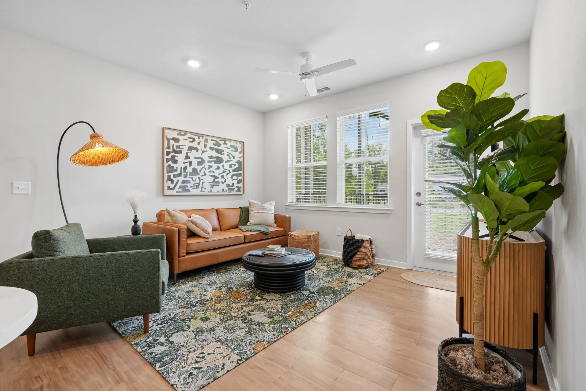 Stylish living room with a brown leather sofa, green accent chair, and coffee table.